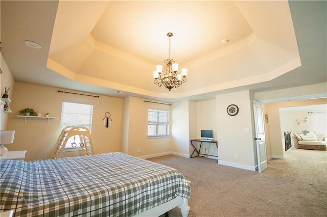 carpeted bedroom featuring a raised ceiling, multiple windows, and baseboards