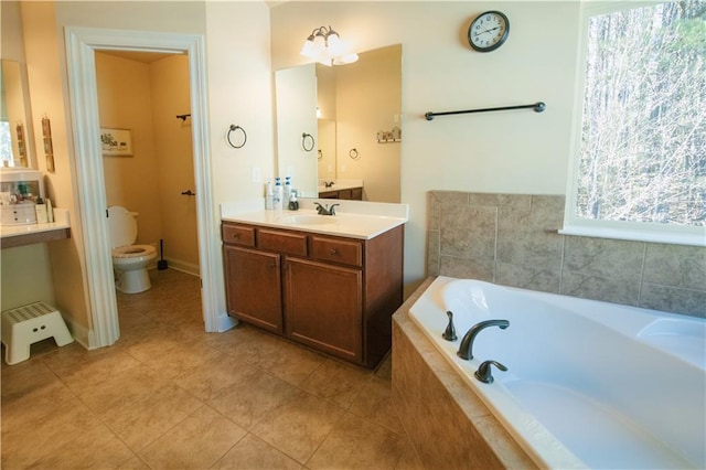 full bathroom featuring vanity, a garden tub, toilet, and tile patterned floors