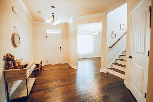 foyer with stairs, dark wood-type flooring, ornamental molding, and a chandelier