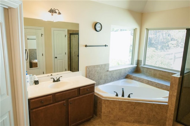 bathroom with vanity, lofted ceiling, a bath, and a stall shower