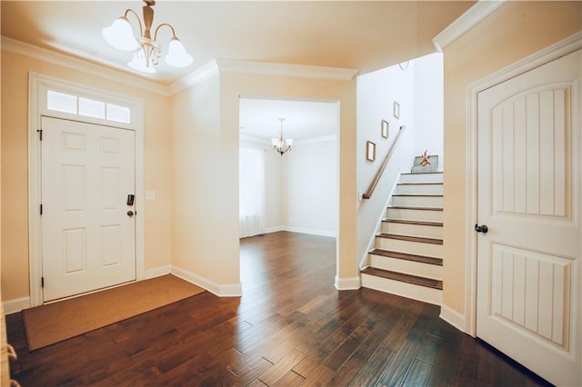 entrance foyer featuring stairway, dark wood-style floors, baseboards, crown molding, and a notable chandelier