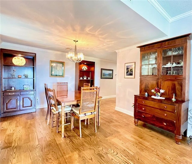 dining room featuring a chandelier, light wood-type flooring, and crown molding