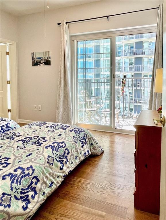 bedroom featuring access to outside and wood finished floors
