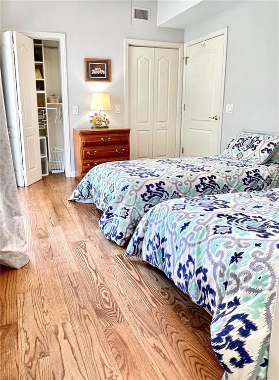 bedroom featuring light wood-type flooring, a closet, and visible vents