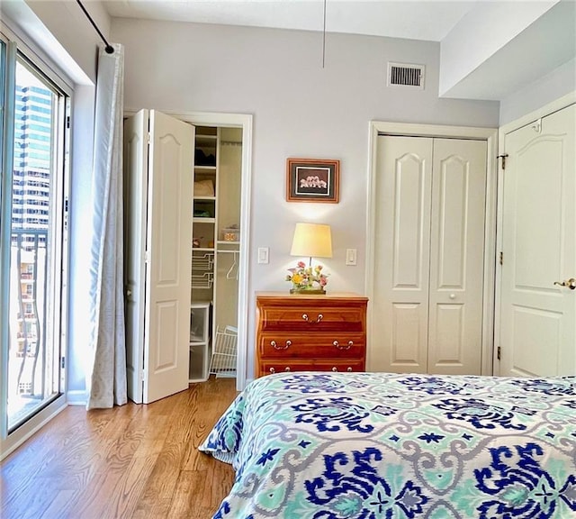 bedroom with a closet, light wood finished floors, and visible vents