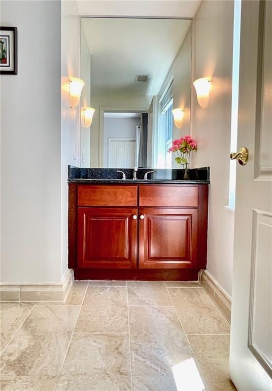 bathroom featuring vanity, baseboards, and visible vents