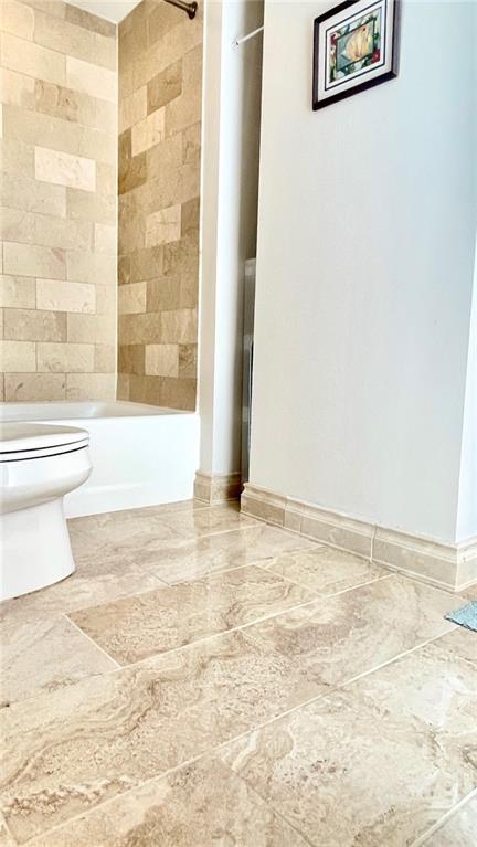 bathroom featuring toilet and bathing tub / shower combination