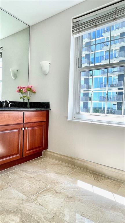 bathroom featuring baseboards, plenty of natural light, and vanity