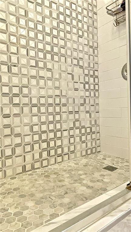 interior details featuring tiled shower