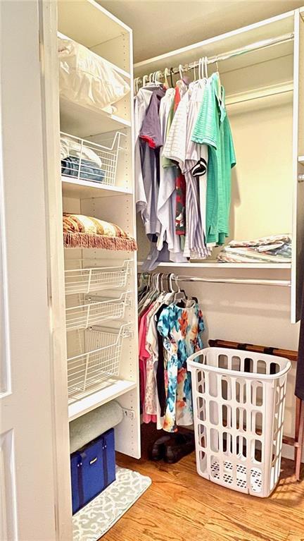 walk in closet with wood finished floors