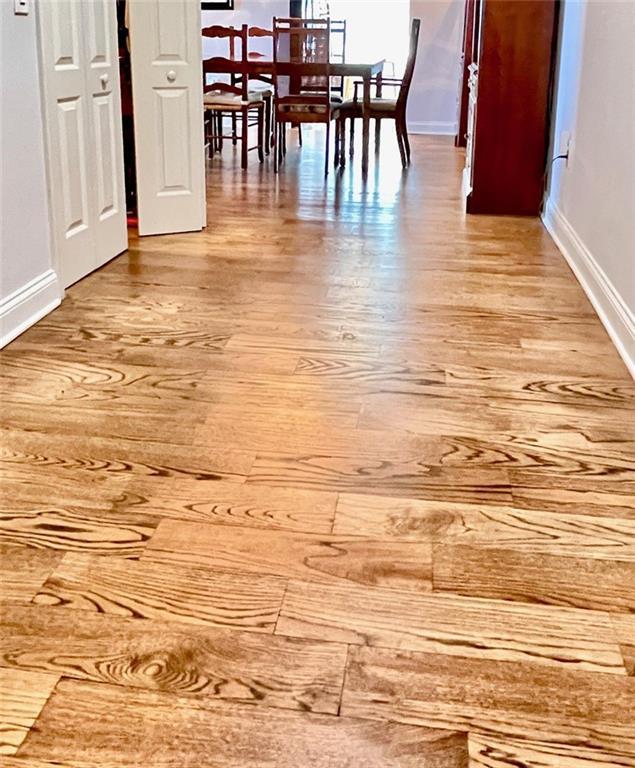unfurnished dining area featuring wood finished floors and baseboards