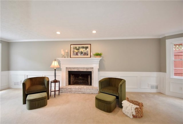5040 Puritan Dr, Sugar Hill, GA 30518 - carpeted living area with wainscoting, a brick fireplace, a decorative wall, recessed lighting, and ornamental molding