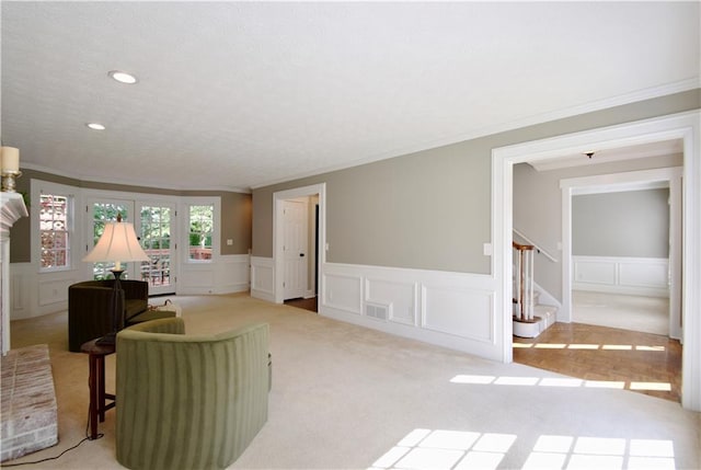 5040 Puritan Dr, Sugar Hill, GA 30518 - living area featuring crown molding, a decorative wall, carpet floors, a wainscoted wall, and stairs