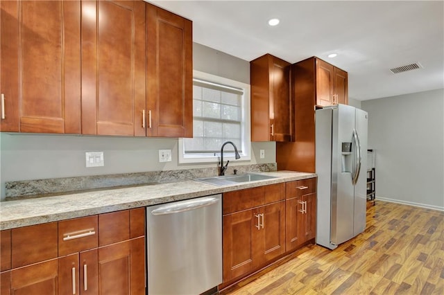 kitchen featuring visible vents, stainless steel appliances, light countertops, light wood-style floors, and a sink