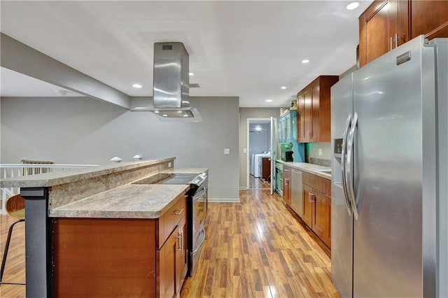 kitchen featuring a kitchen bar, island exhaust hood, stainless steel appliances, and light countertops