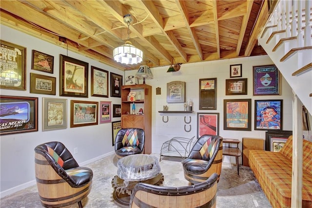 living area featuring beam ceiling, stairway, and baseboards