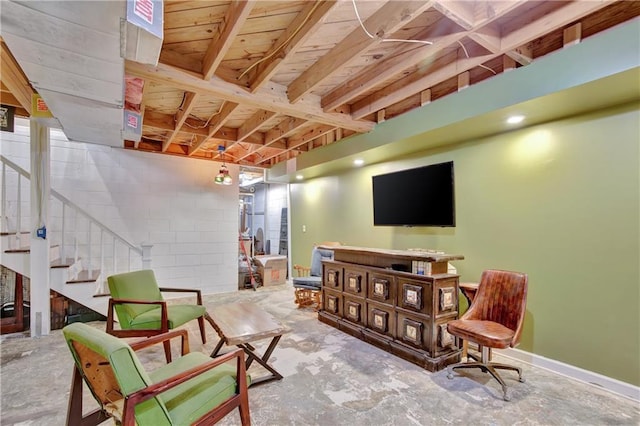 interior space with concrete block wall, stairs, and concrete flooring