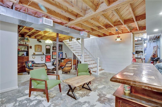 living area featuring concrete block wall, stairs, visible vents, and unfinished concrete flooring