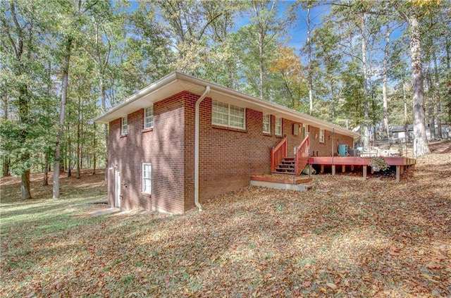 exterior space featuring brick siding and a deck