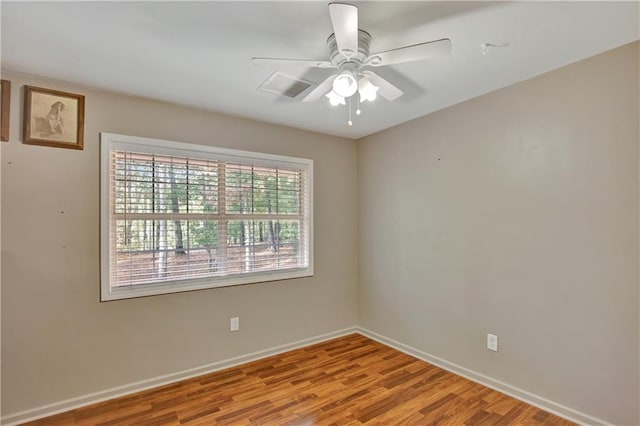 empty room featuring a ceiling fan, light wood-style flooring, and baseboards