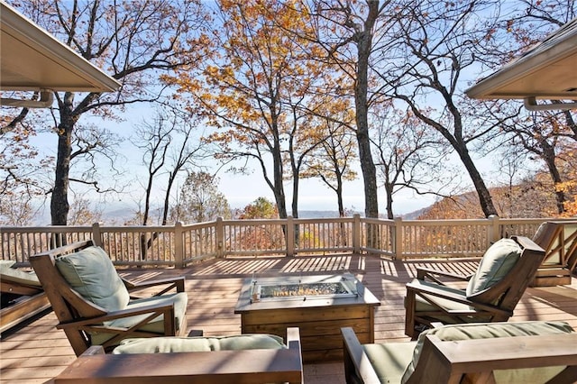 wooden deck featuring a mountain view and a fire pit