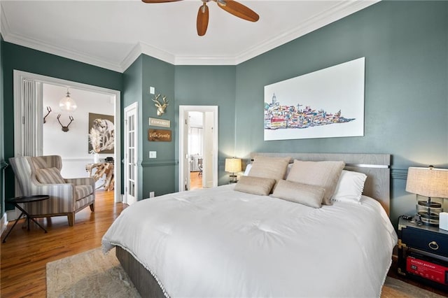 bedroom with hardwood / wood-style flooring, ceiling fan, and ornamental molding