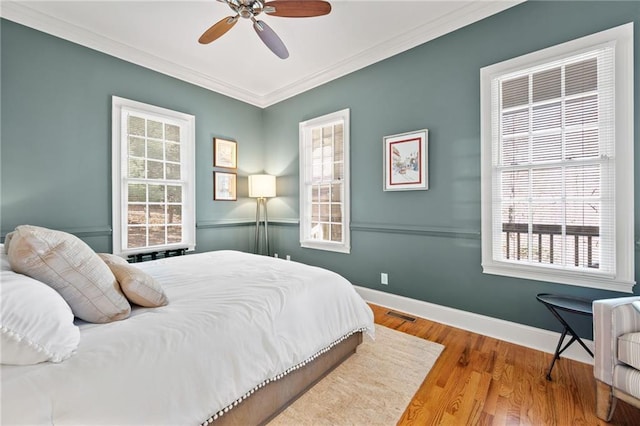 bedroom featuring ceiling fan, light wood-type flooring, and ornamental molding