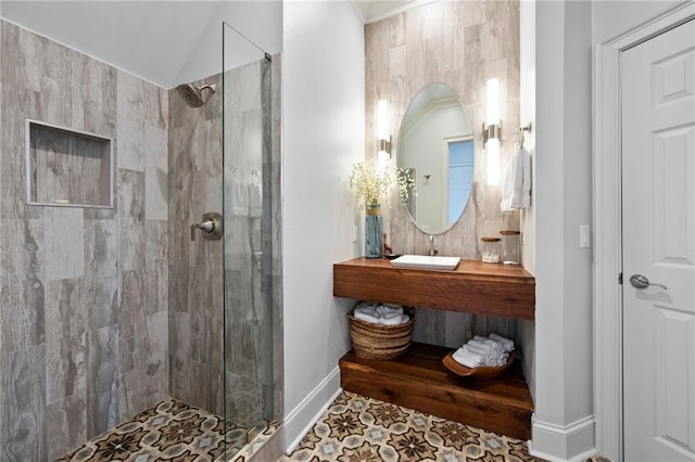 bathroom with sink, tile patterned flooring, vaulted ceiling, and tiled shower