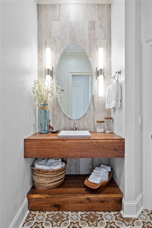 bathroom featuring tile patterned flooring, crown molding, and sink