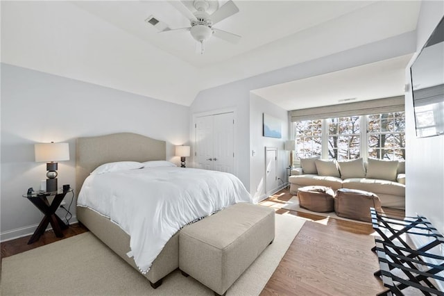 bedroom with ceiling fan, a closet, wood-type flooring, and lofted ceiling