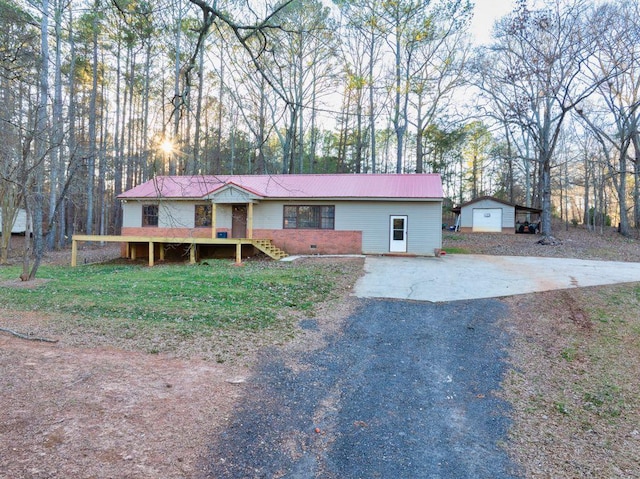 ranch-style house with a garage, an outbuilding, and a front yard