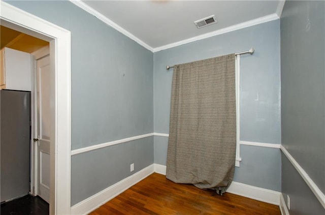 empty room with crown molding and wood-type flooring