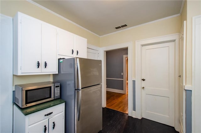 kitchen featuring appliances with stainless steel finishes, white cabinets, and dark wood-type flooring