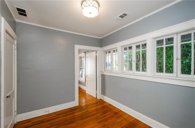 unfurnished room with crown molding and wood-type flooring