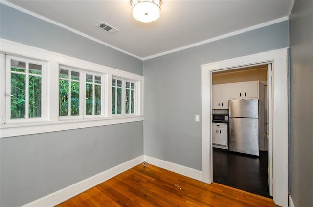 empty room with crown molding and wood-type flooring