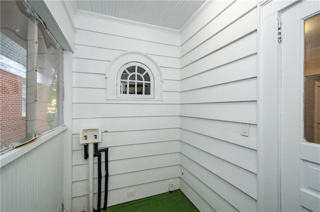 interior space featuring crown molding and wooden walls