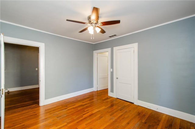 unfurnished bedroom with crown molding, hardwood / wood-style flooring, and ceiling fan