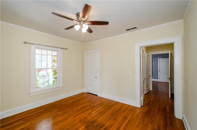 unfurnished room with ornamental molding, ceiling fan, and dark hardwood / wood-style flooring