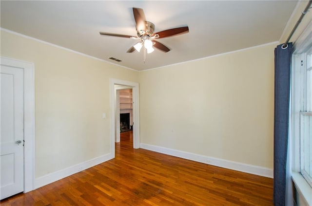 unfurnished room featuring hardwood / wood-style floors, crown molding, and ceiling fan