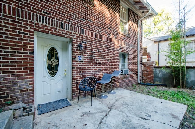 view of exterior entry featuring a patio area and cooling unit