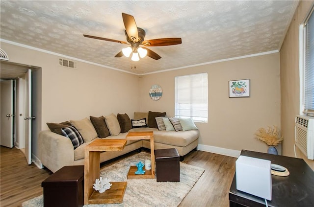 living room with crown molding, hardwood / wood-style flooring, a textured ceiling, and ceiling fan