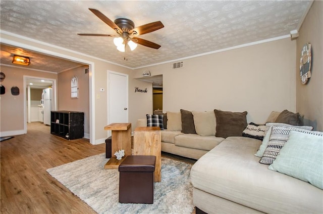 living room featuring hardwood / wood-style floors, crown molding, a textured ceiling, and ceiling fan