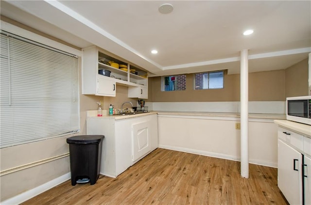 kitchen featuring white cabinetry, sink, and light wood-type flooring