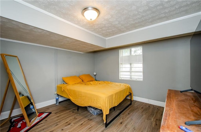 bedroom featuring ornamental molding, a textured ceiling, and hardwood / wood-style flooring