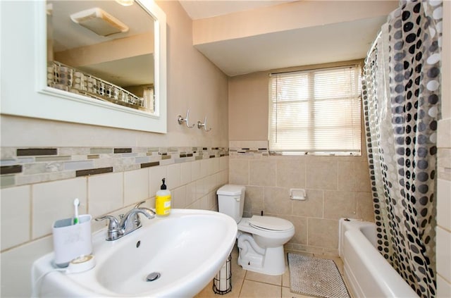 full bathroom with sink, shower / bath combo, toilet, tile patterned floors, and tile walls