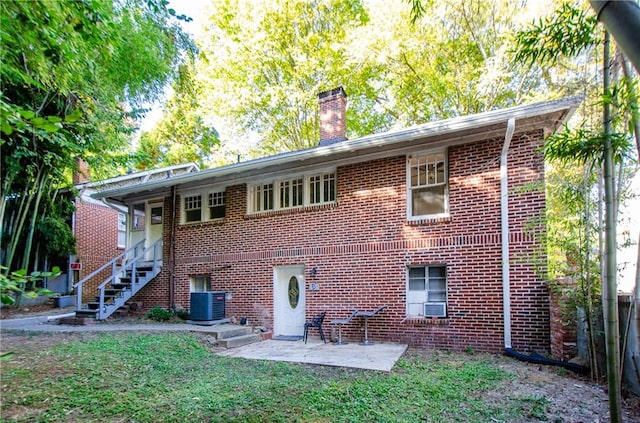 rear view of property featuring central air condition unit, a patio, cooling unit, and a lawn