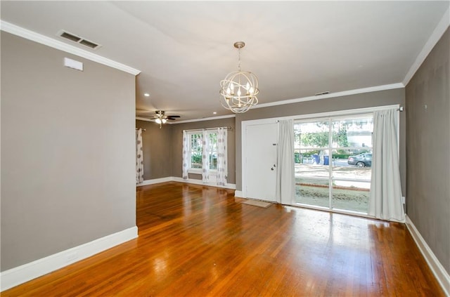 spare room with ornamental molding, hardwood / wood-style floors, a healthy amount of sunlight, and ceiling fan with notable chandelier