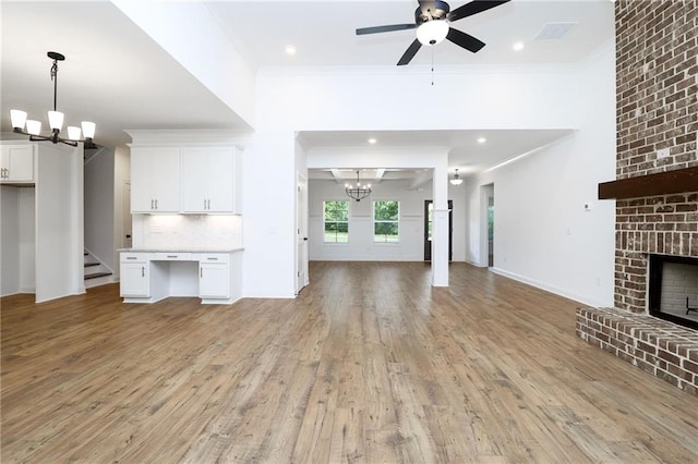 2113 Ella Springs Dr, Covington, GA 30014 - unfurnished living room featuring a chandelier, ornamental molding, light wood finished floors, a brick fireplace, and a ceiling fan