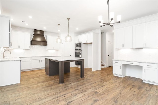 2113 Ella Springs Dr, Covington, GA 30014 - kitchen with custom range hood, tasteful backsplash, a sink, built in microwave, and light wood finished floors