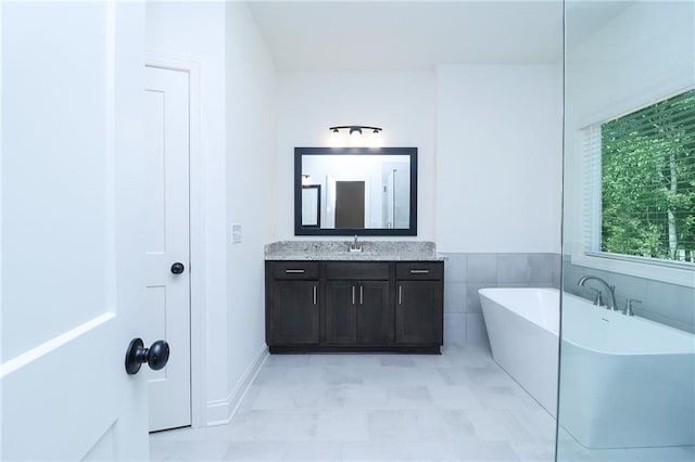 2113 Ella Springs Dr, Covington, GA 30014 - bathroom with a freestanding tub, vanity, and baseboards